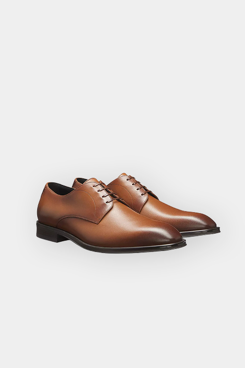 Une paire de chaussures en cuir marron avec des lacets, représentée sur un fond blanc.