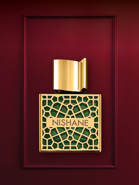 Sur un fond rouge profond, on aperçoit un flacon de parfum de luxe avec un design en or et en cristaux. En dessous se trouve le bouchon du flacon. Au-dessus, le texte « CADEAUX DE LUXE » est écrit en blanc.