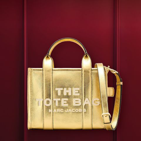 Un sac à main structuré en métal avec des poignées devant un fond bordeaux. Au-dessus, on peut lire le mot « WUNSCHTASCHE ».